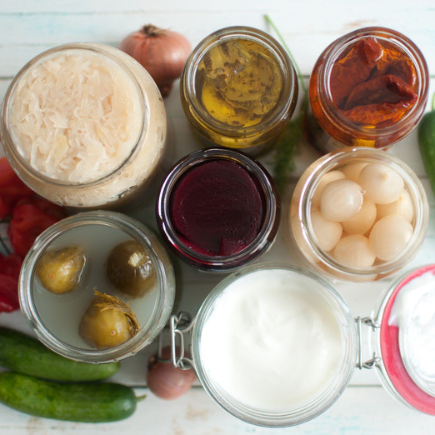 Jars of fermented foods including sauerkraut pickles and yogurt